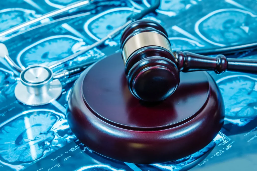 A gavel sitting on top of pictures of an MRI of a brain.